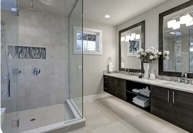 Bright bathroom with a frameless glass shower enclosure and double vanity in Las Vegas